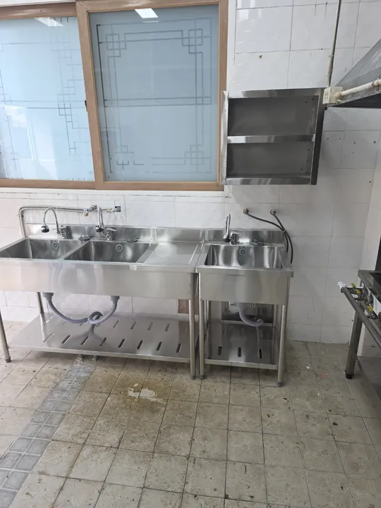 식당 주방에 새로 설치된 3조 개수대와 보조 개수대, 상부 선반